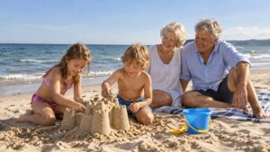 Dziadkowie spędzający wakacje z wnukami na plaży
